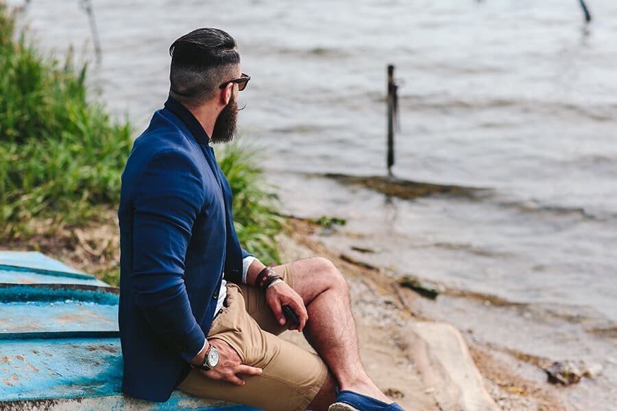 Photo of a man looking into the distance by the shore